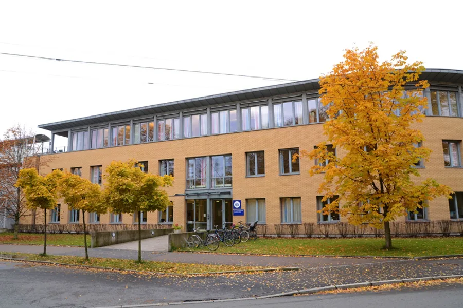 En bygning med trær foran seg