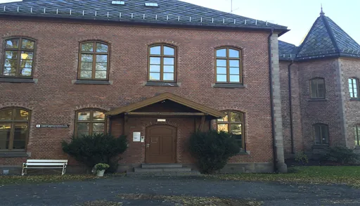 En murbygning med en benk foran seg