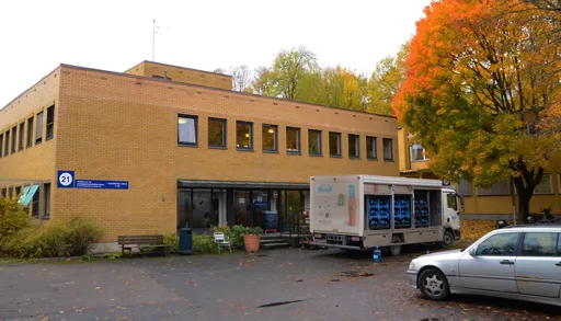 En hvit lastebil parkert utenfor James Charnley House