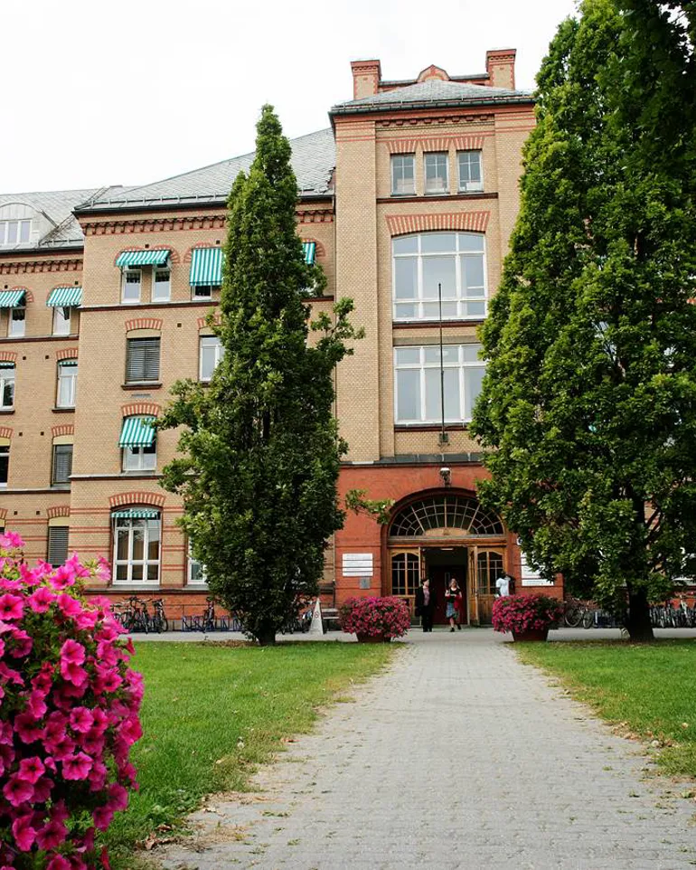 En bygning med trær og blomster foran seg