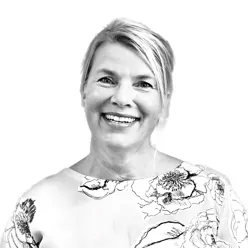 Portrettbilde av Liv Skinnes hvor hun smiler og har håret opp i en hestehale.