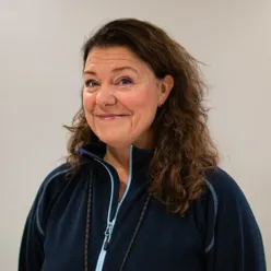 Portrettbilde av Carita Rist som smiler lurt til kameraet.