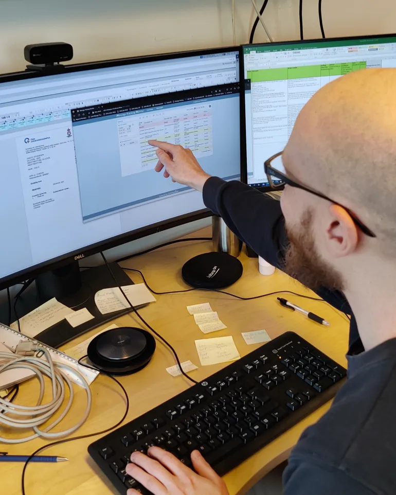 Foto: Mann peker på interessant info på PC-skjerm