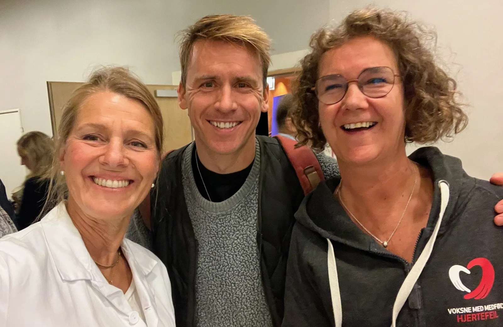 En gruppe mennesker som smiler