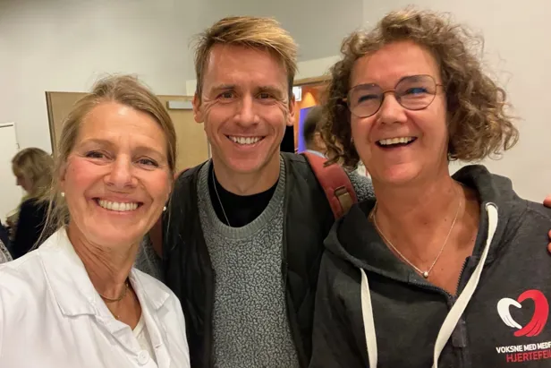 En gruppe mennesker som smiler