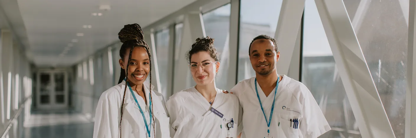 tre smilende bioingeniører i hvit uniform