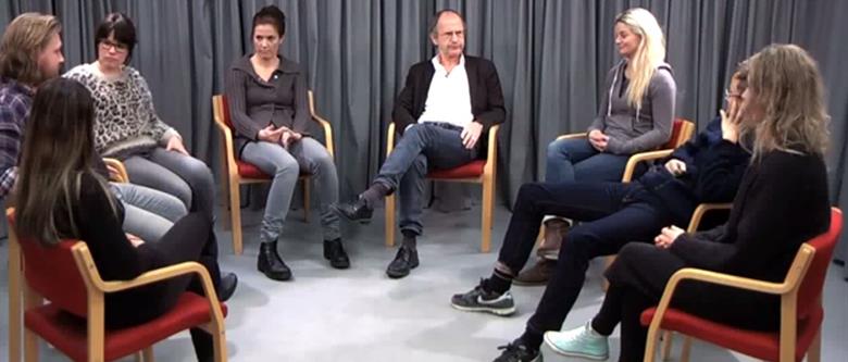 En gruppe mennesker som sitter i stoler