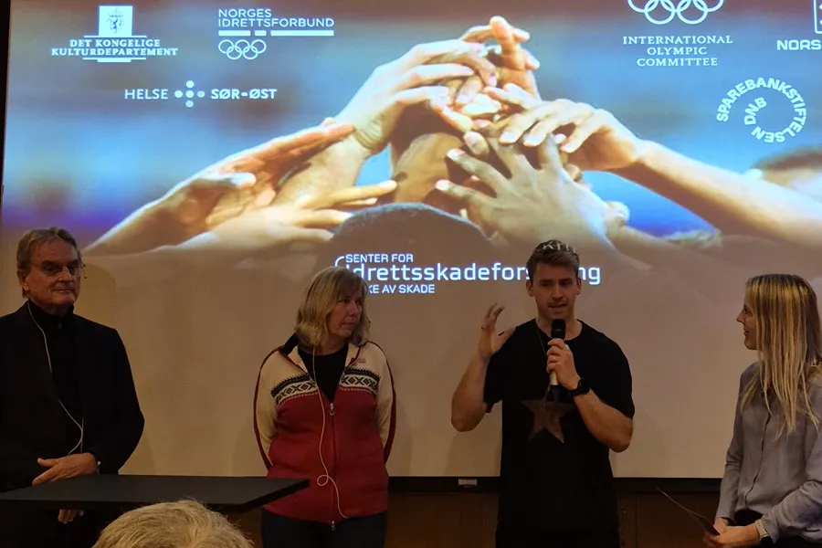 En gruppe mennesker som står foran en skjerm med en tegneserie
