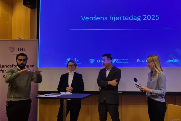 En gruppe mennesker som står foran en skjerm