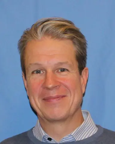 En mann som smiler til kameraet