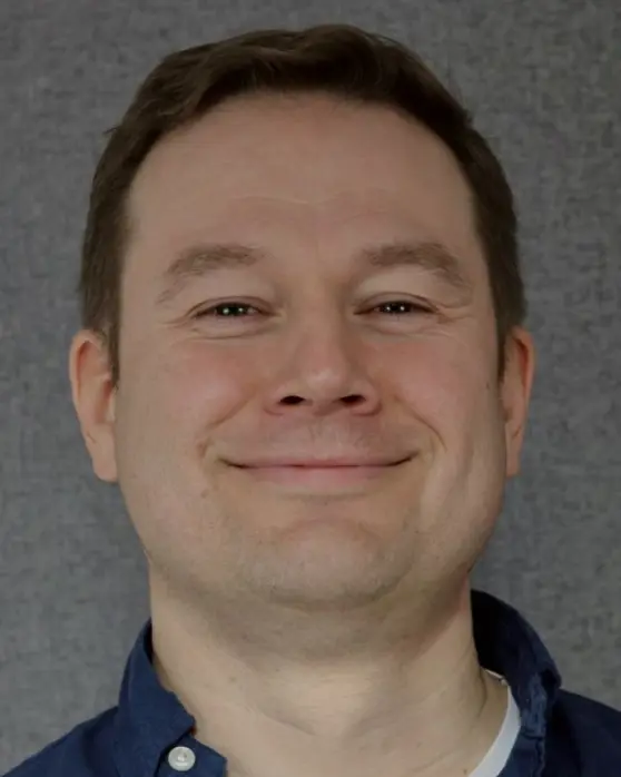 En mann som smiler til kameraet