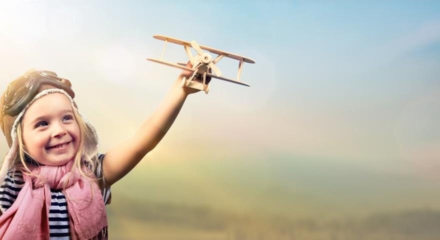 Girl holding a toy airplaine