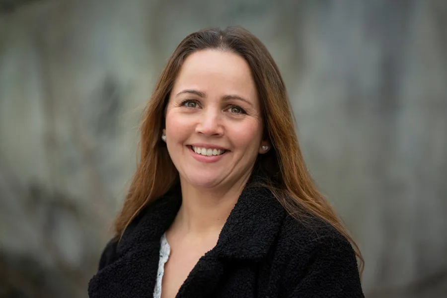 En kvinne med langt hår som smiler