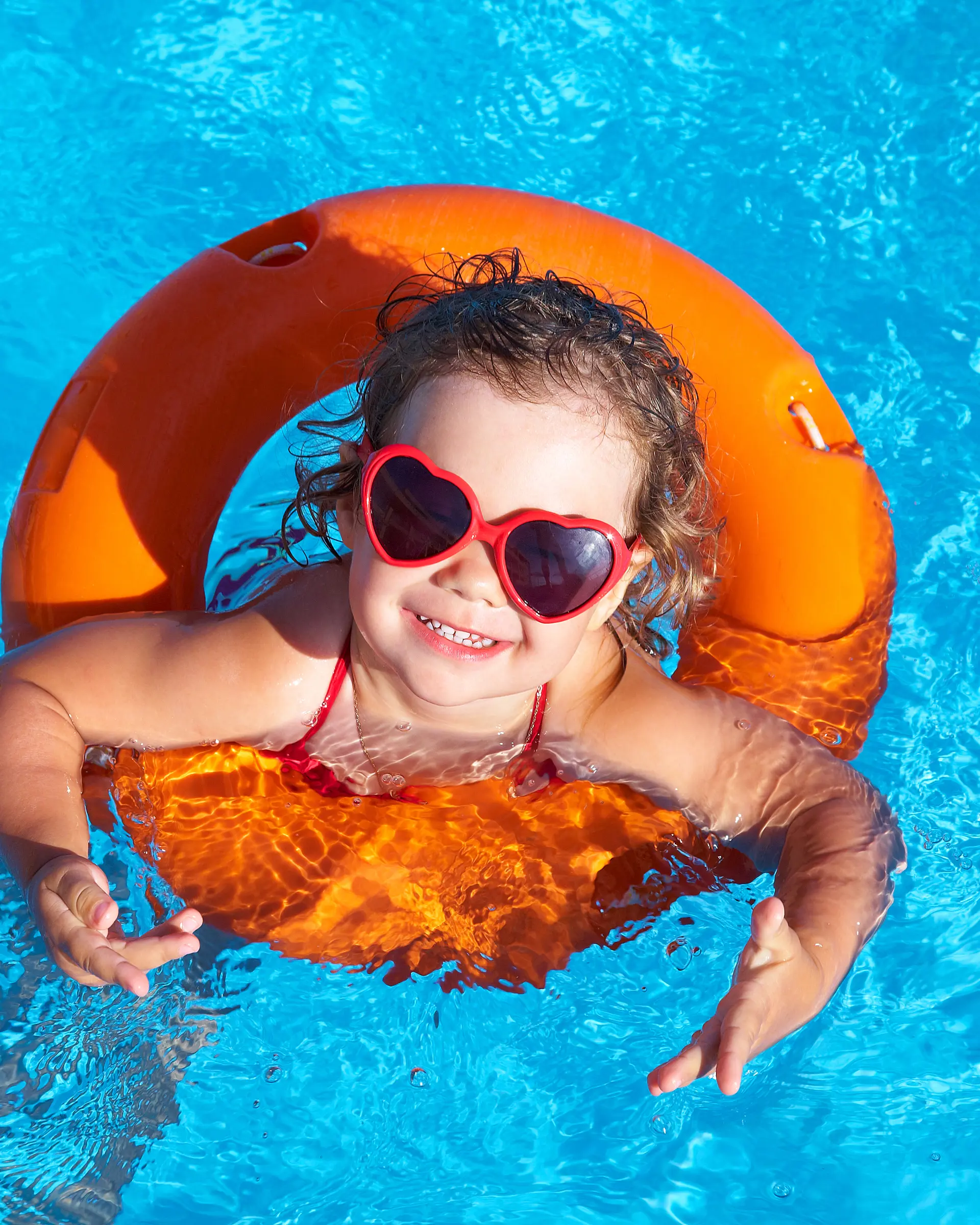 Barn med solbriller og badering i basseng.