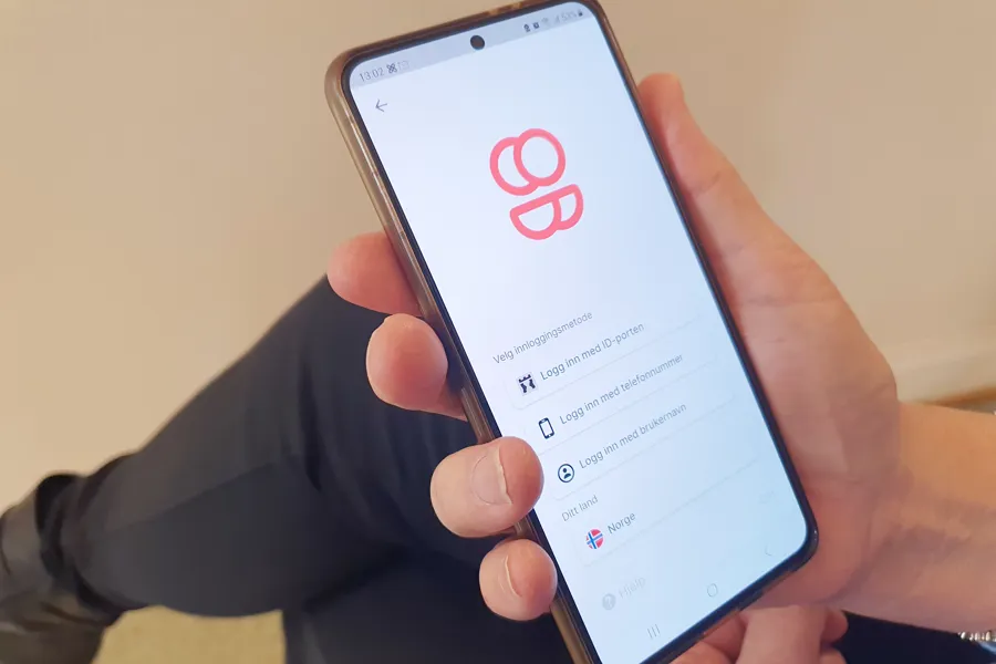 En hånd som holder en mobiltelefon med MyDignio-appen åpen