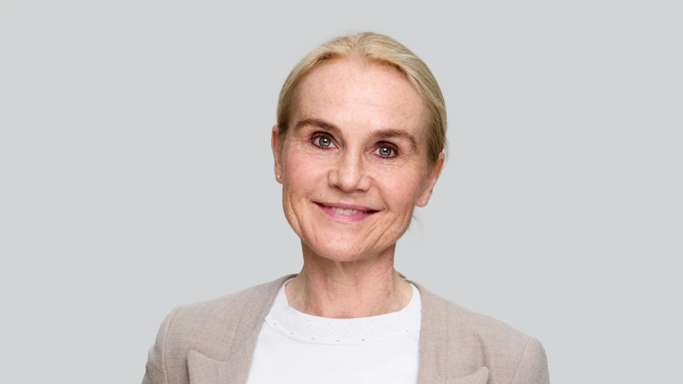 Portrettbilde av Mona-Elisabeth Rootwelt-Revheim som ser smilende inn i kameraet.