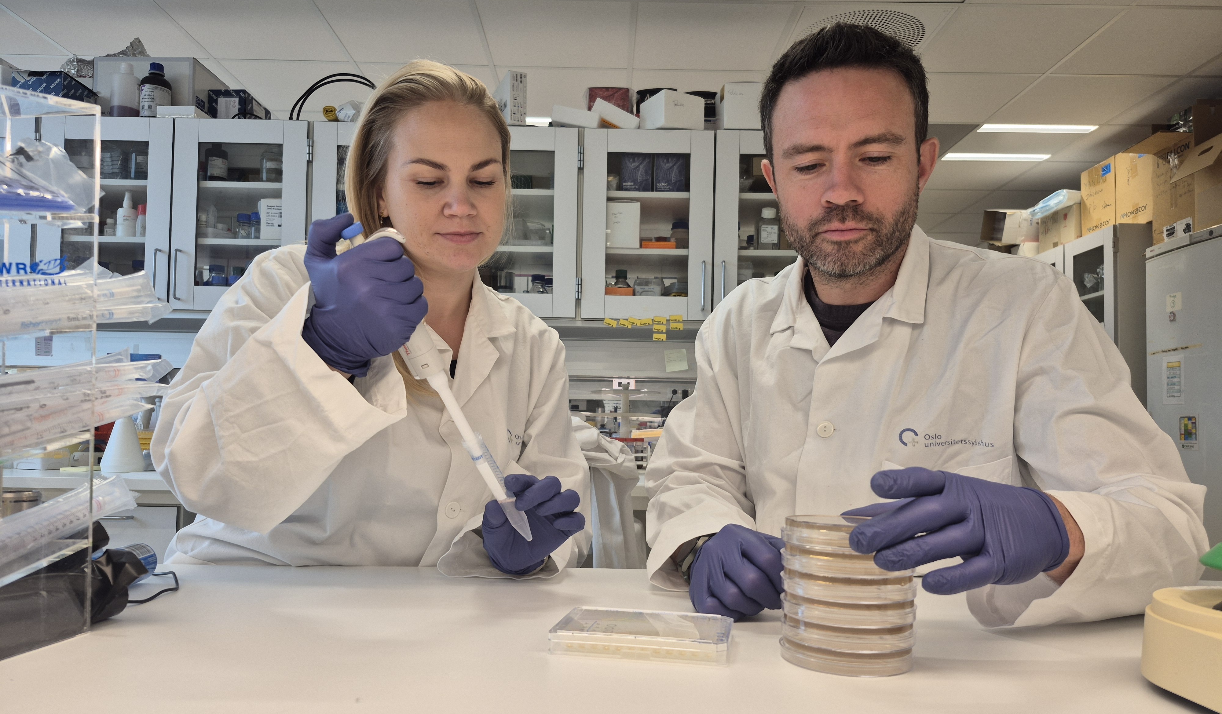 En mann og en kvinne i laboratoriefrakker i et laboratorium