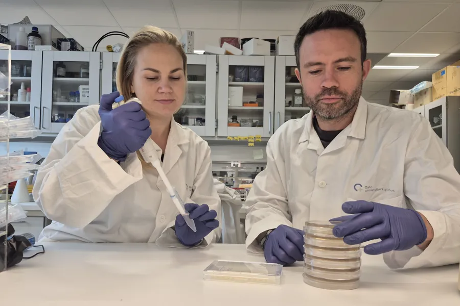 En mann og en kvinne i laboratoriefrakker i et laboratorium