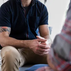 En mann som sitter i en stol