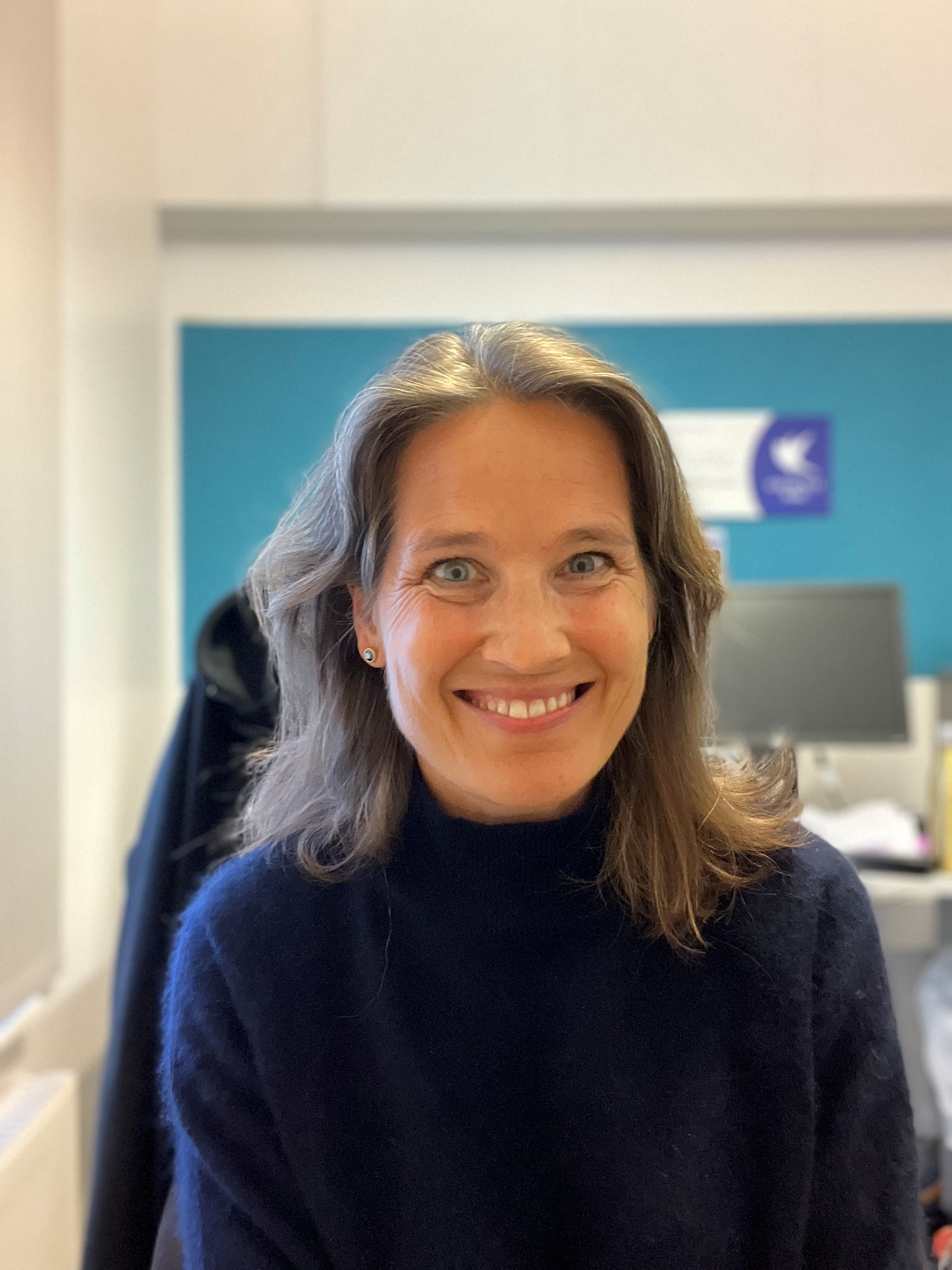 En kvinne som smiler til kameraet