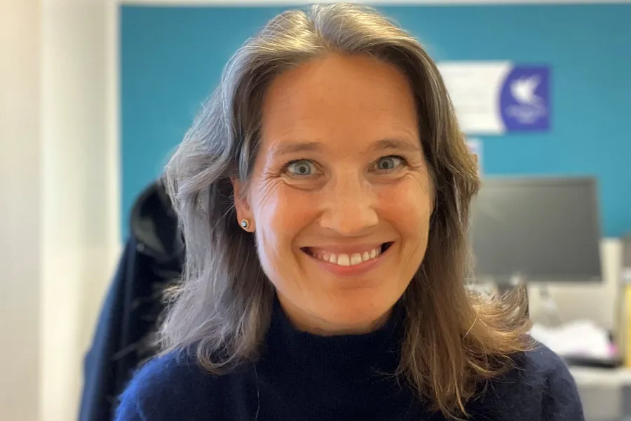 En kvinne som smiler til kameraet