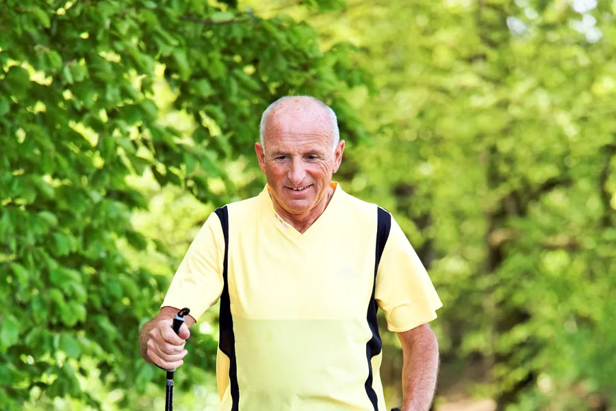 Eldre mann går på tur med staver