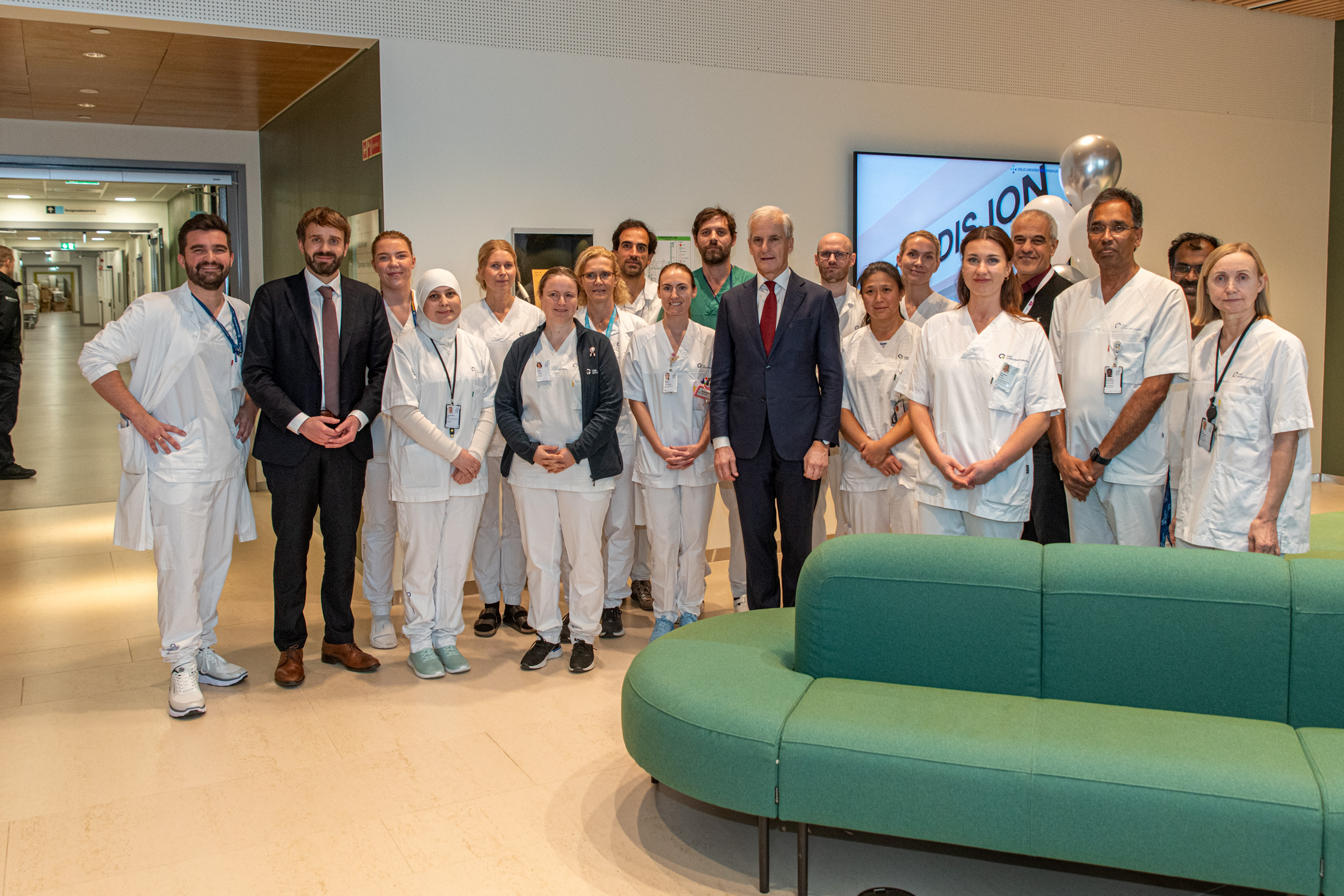 Statsminister Støre og helseminister Vestre poserer sammen med en gruppe ansatte