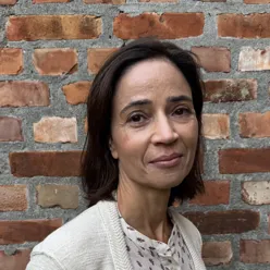 Kvinne foran en murvegg