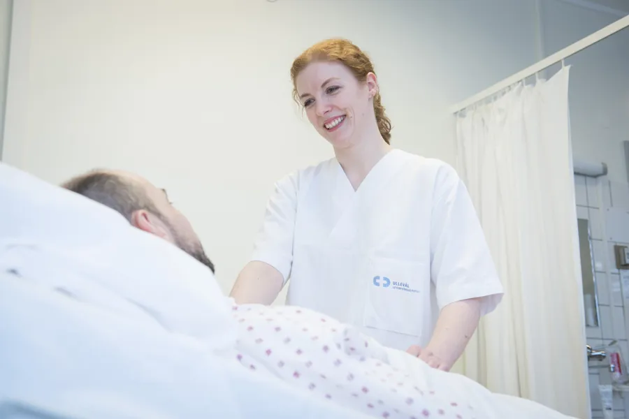 Patient in nbed having a conversation with a nurse