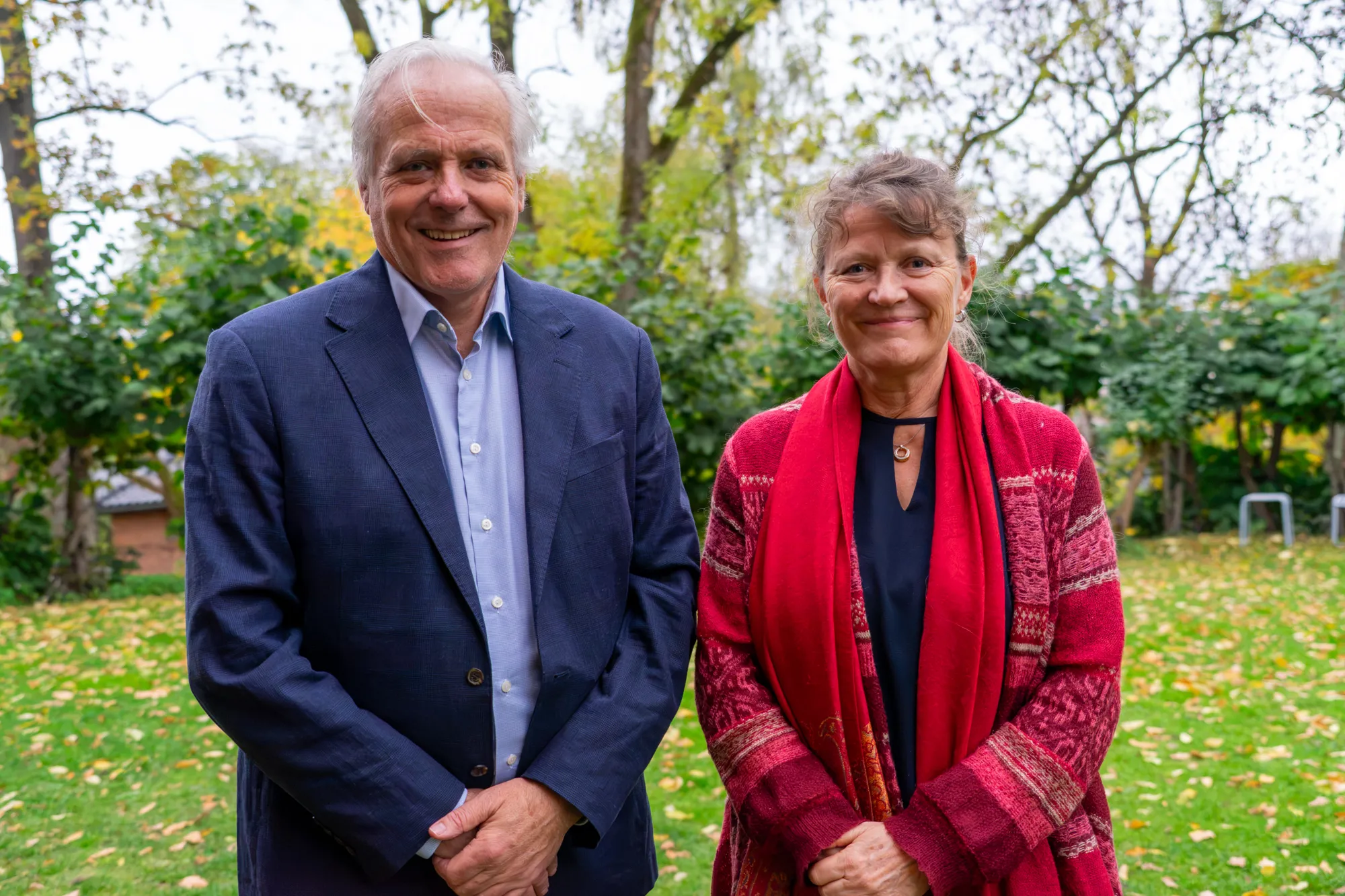 Sigbjørn Smeland og Åslaug Helland står ved siden av hverandre ute på gresset og smiler til kameraet.