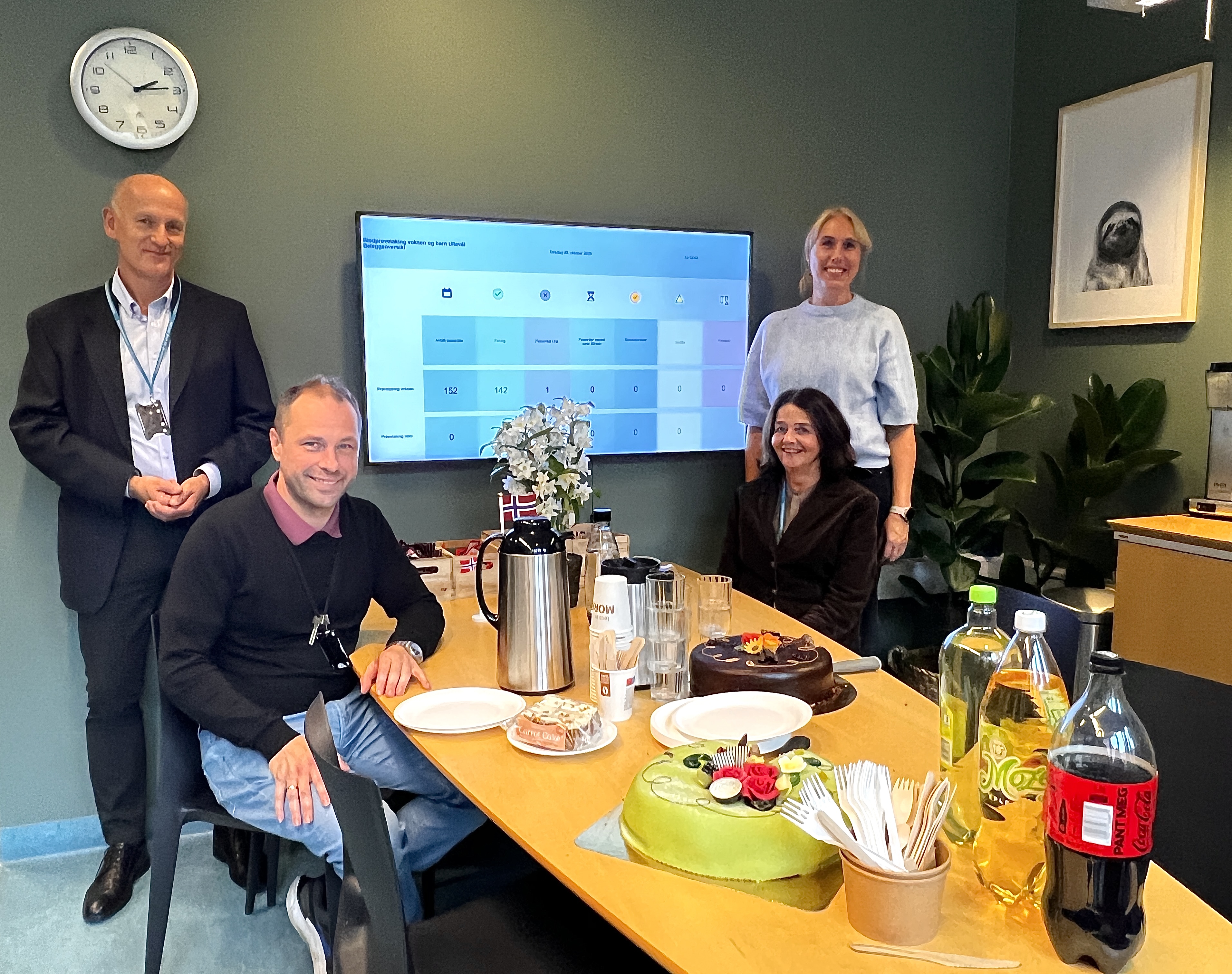 En gruppe mennesker som sitter rundt et bord med mat og drikke