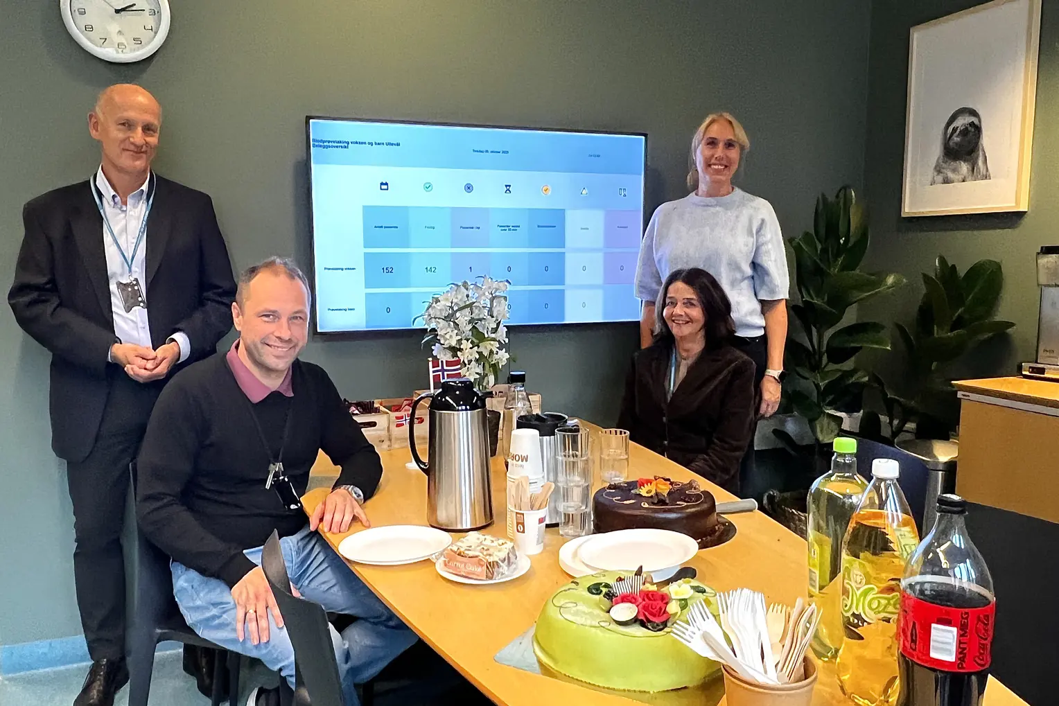 En gruppe mennesker som sitter rundt et bord med mat og drikke