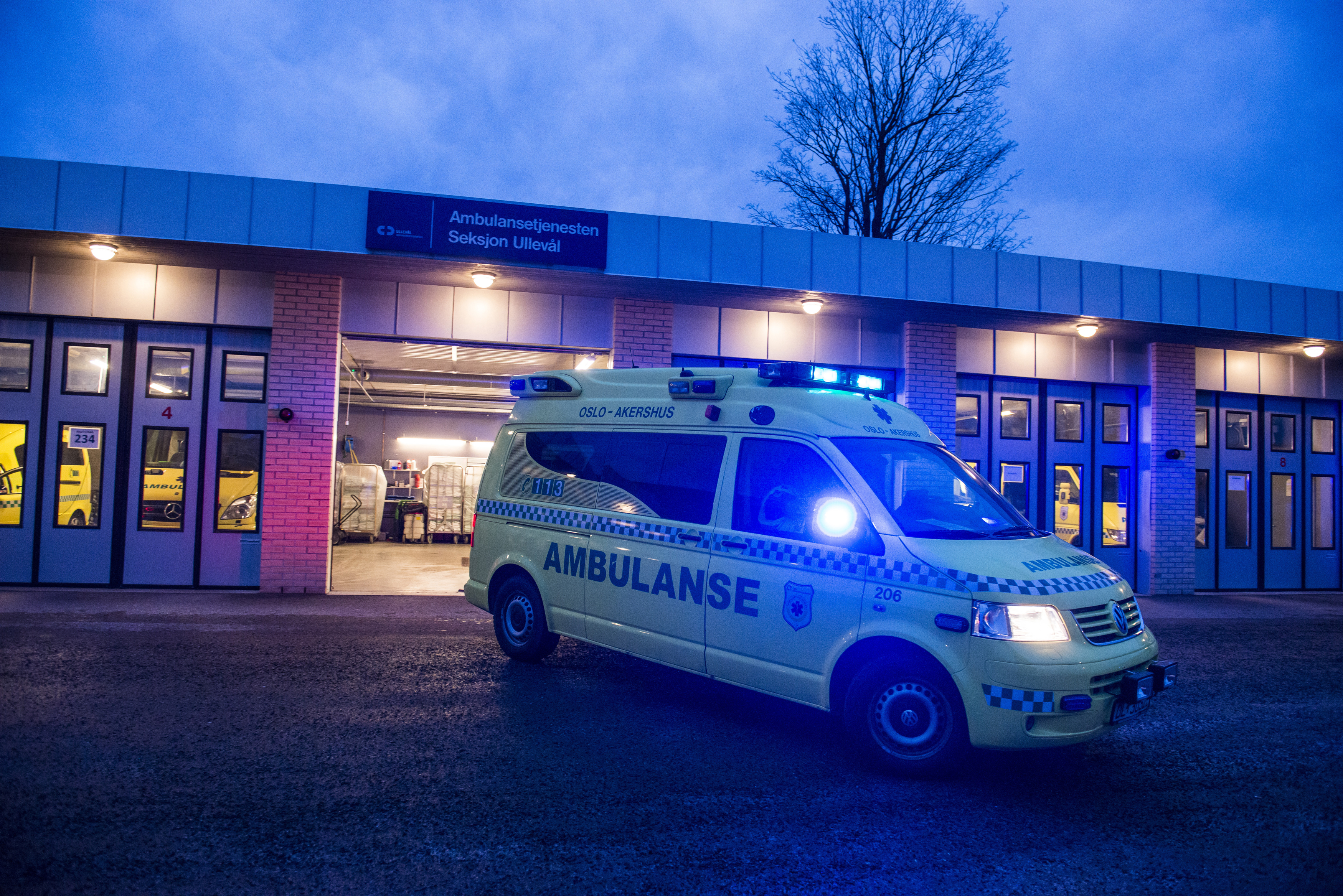 Ambulanse kjører ut av garasjen i grålysningen