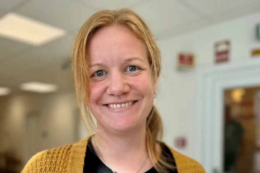 En kvinne som smiler til kameraet