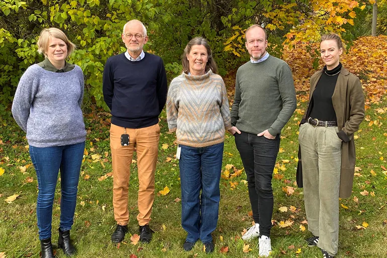 En gruppe mennesker som står i en blomstereng