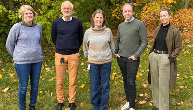 En gruppe mennesker som står i en blomstereng