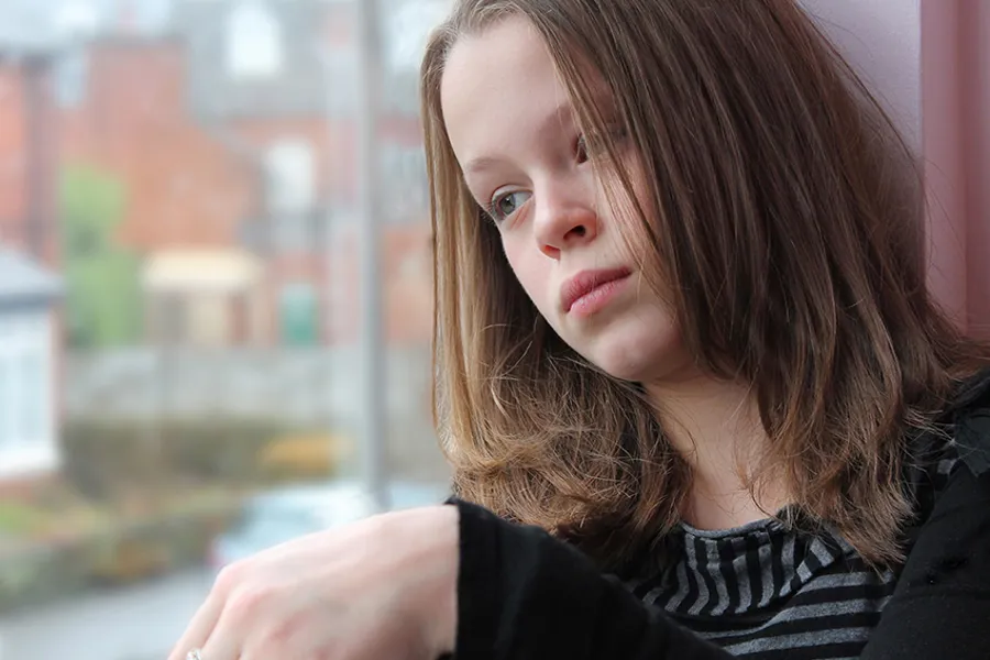 En kvinne som sitter i vinduskarmen