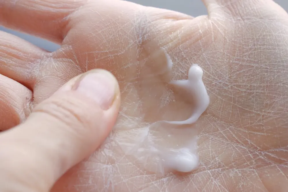 Nærbilde av en persons hånd med et hvitt stoff på