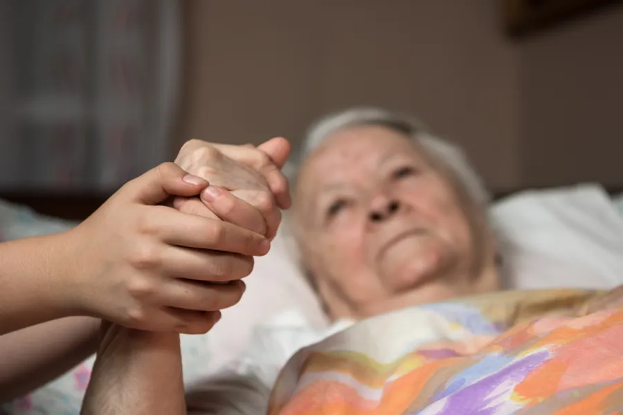 Eldre syk holdes i hånd av ung person