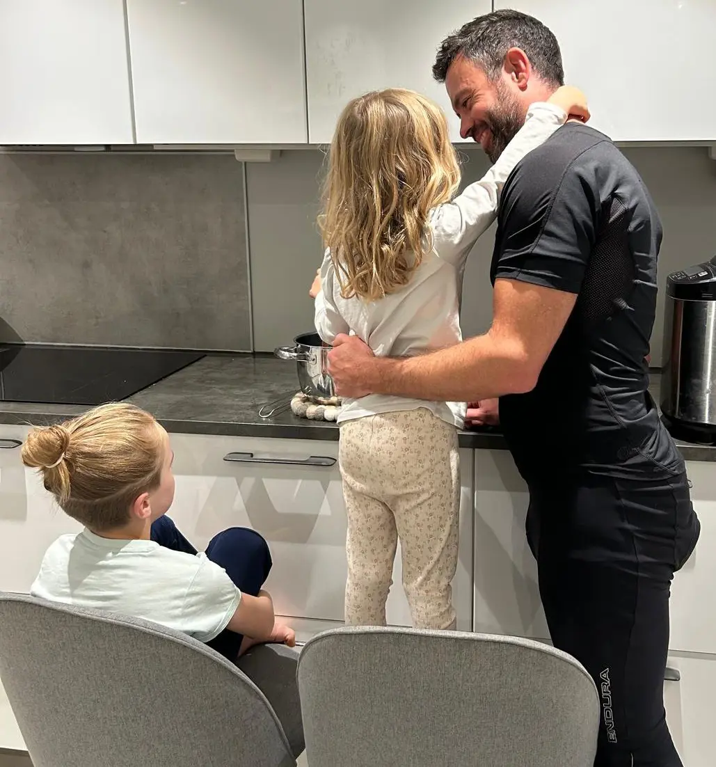 En mann og kvinne som står foran et bord med et barn sittende ved det