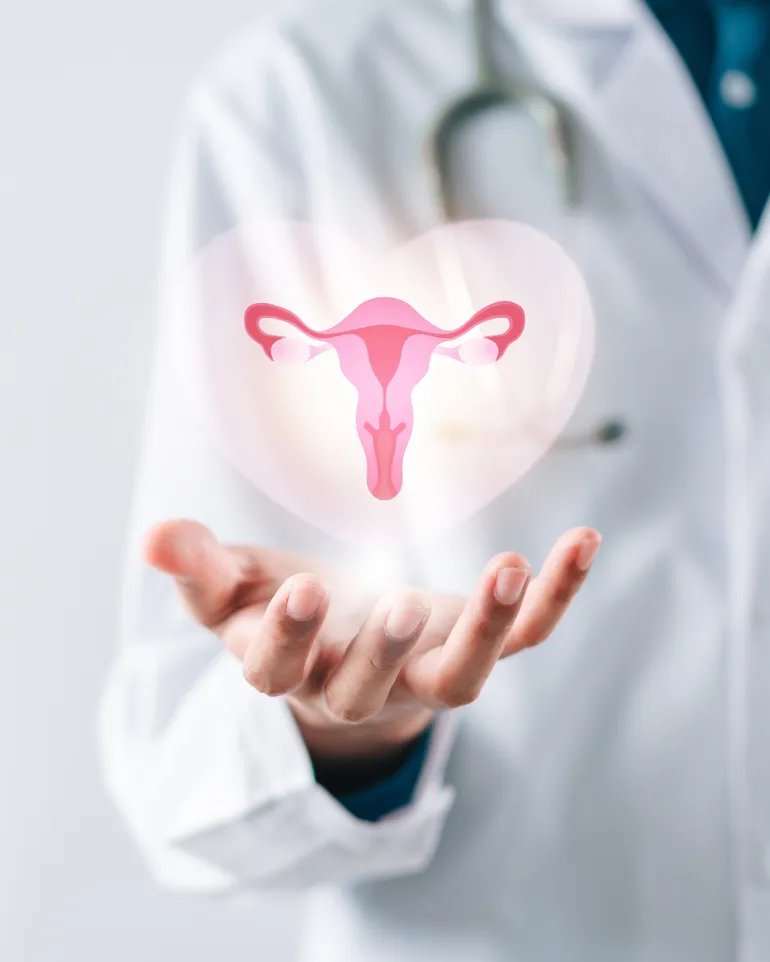 Lege i hvit frakk som holder en virtuell livmor