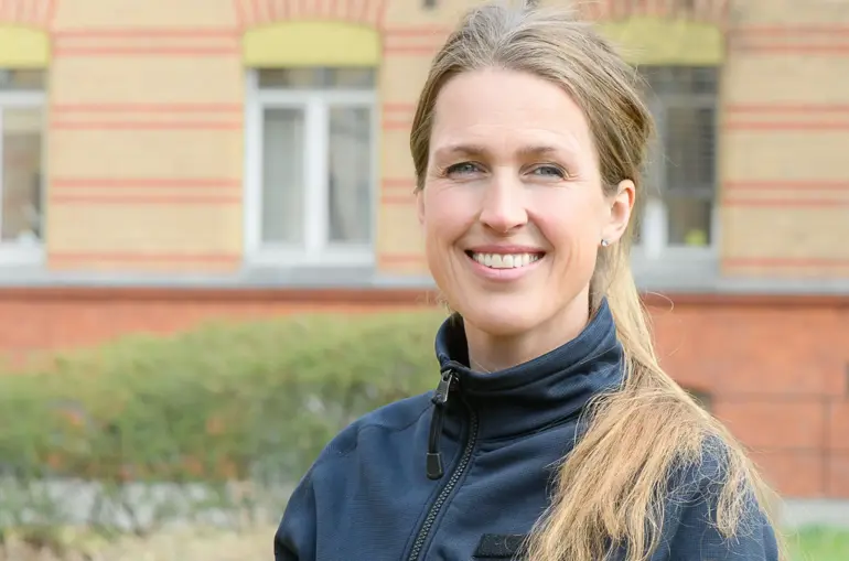 En kvinne som smiler utenfor