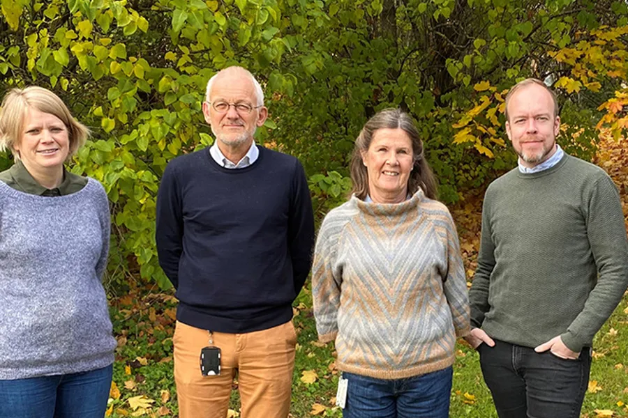 A group of people standing in front of a tree