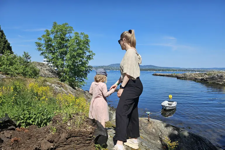 Mor og datter på tur langs sjøen