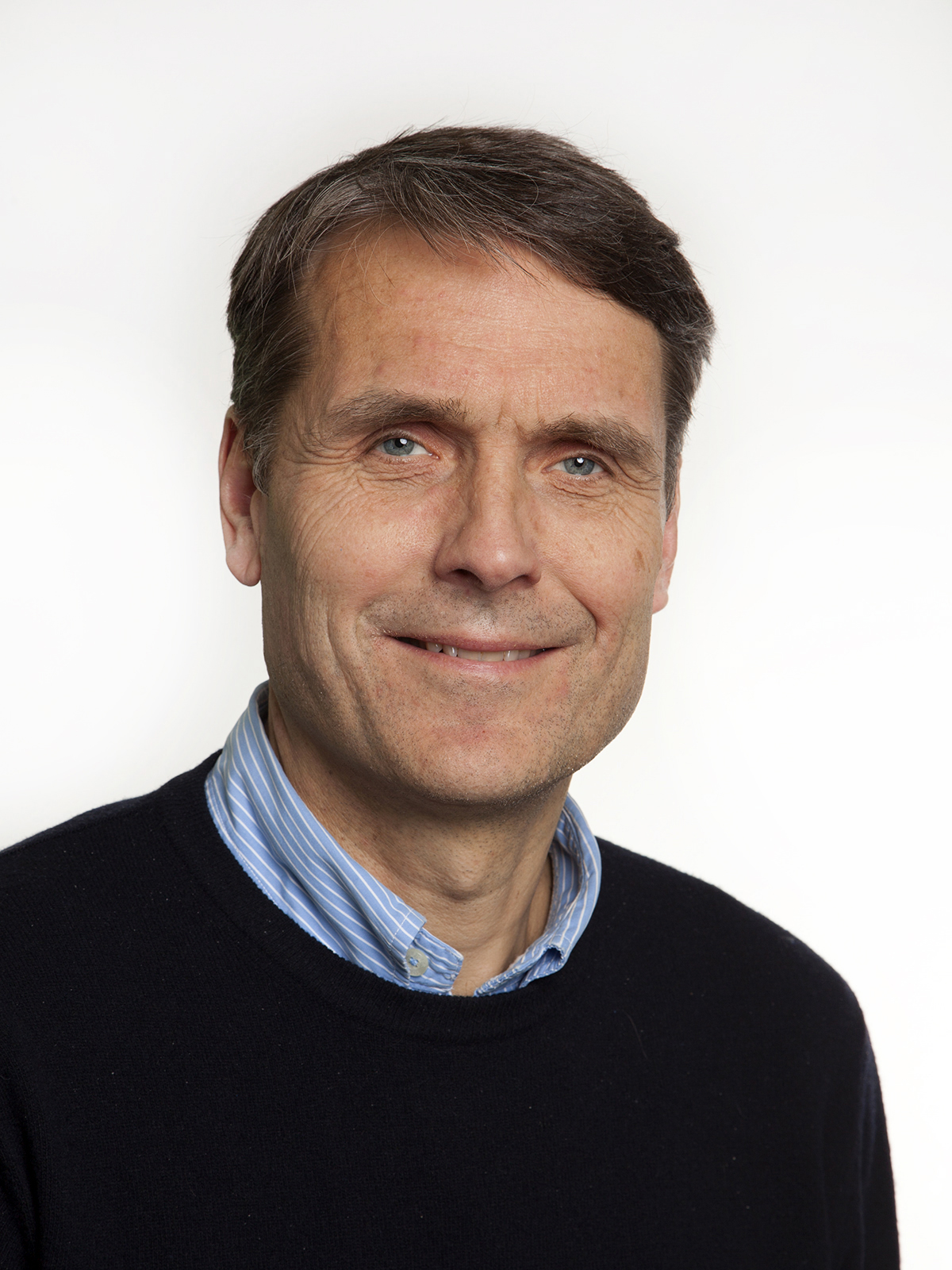 En mann som smiler til kameraet