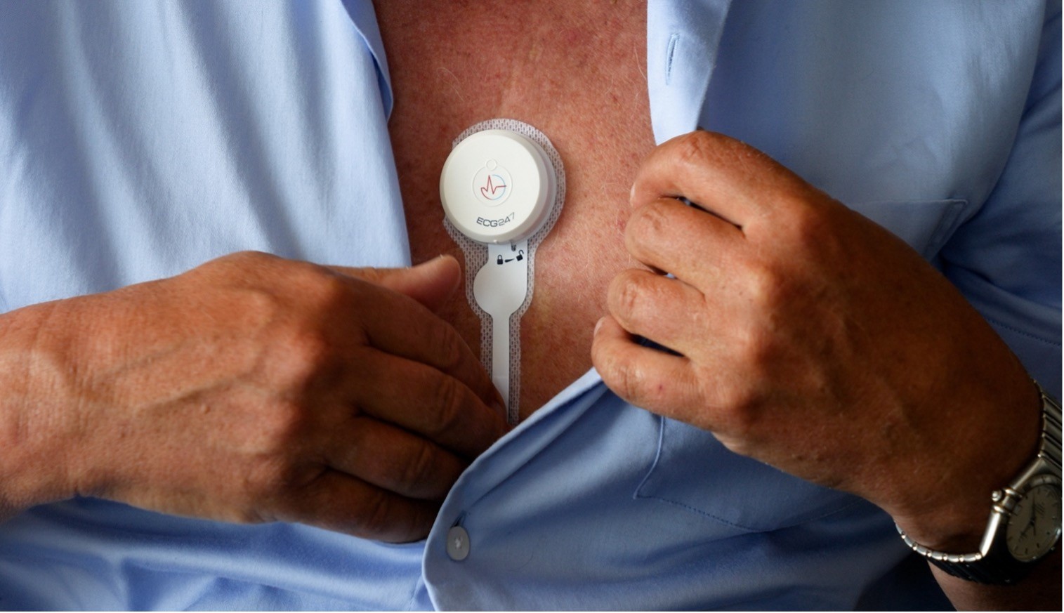 En mann som holder en hvit enhet