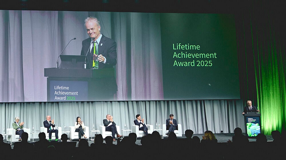 Lars Aabakken står på et podium og tar imot prisen