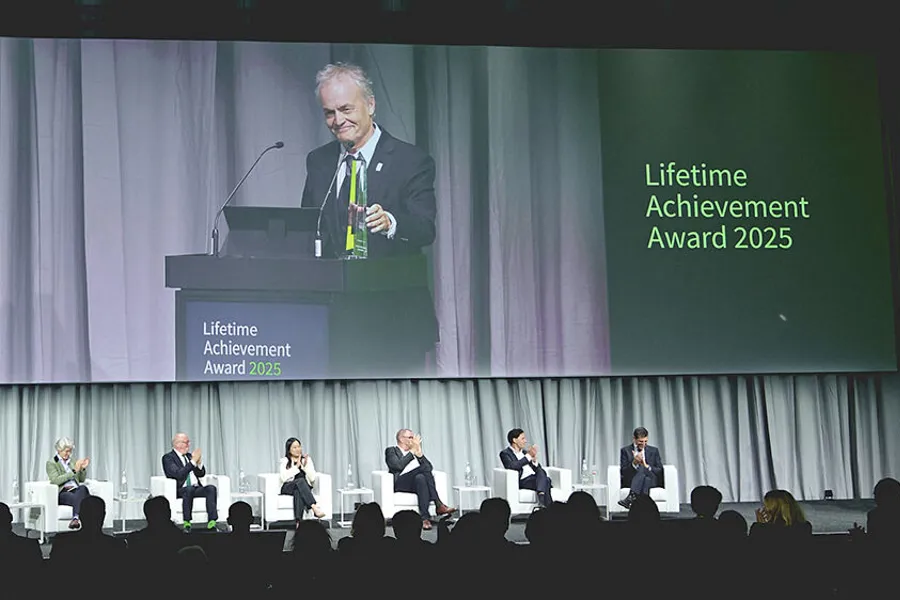 Lars Aabakken står på et podium og tar imot prisen