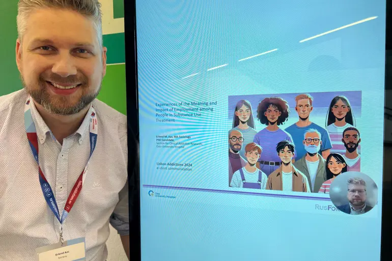 En mann som står ved siden av en bilde-monitor