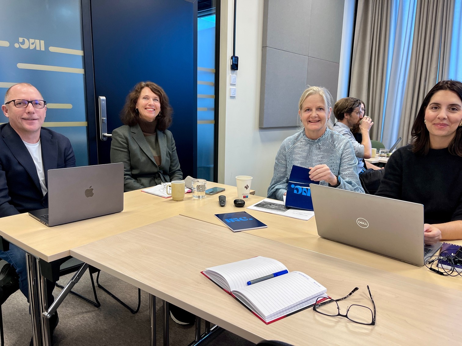 En gruppe mennesker som sitter rundt et bord med bærbare datamaskiner